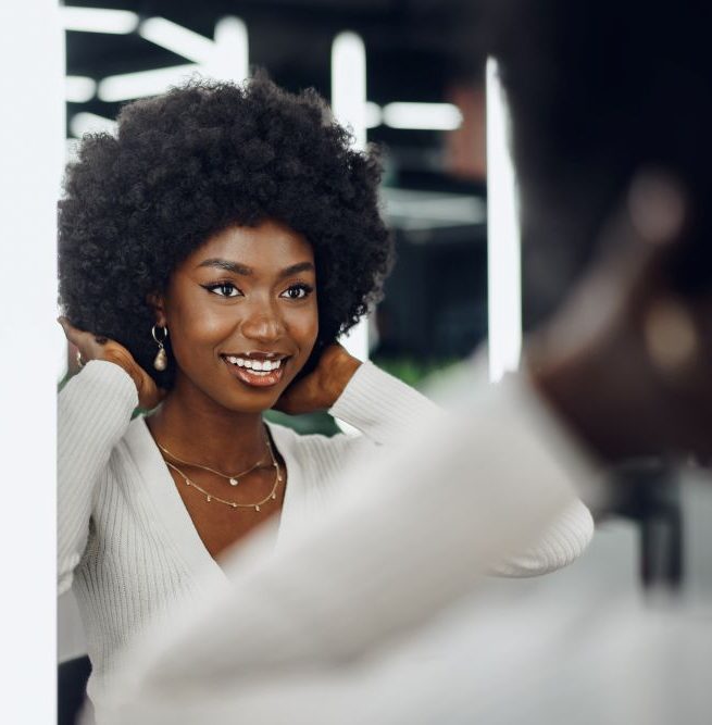 Woman looking at her hair in a mirror