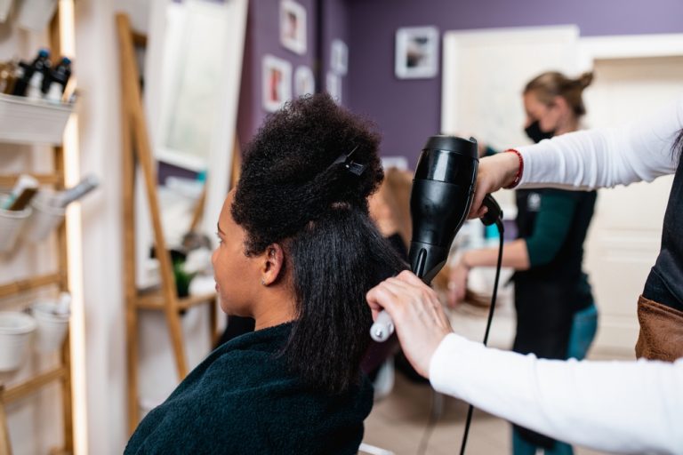 Blowdrying a woman's hair with natural curls